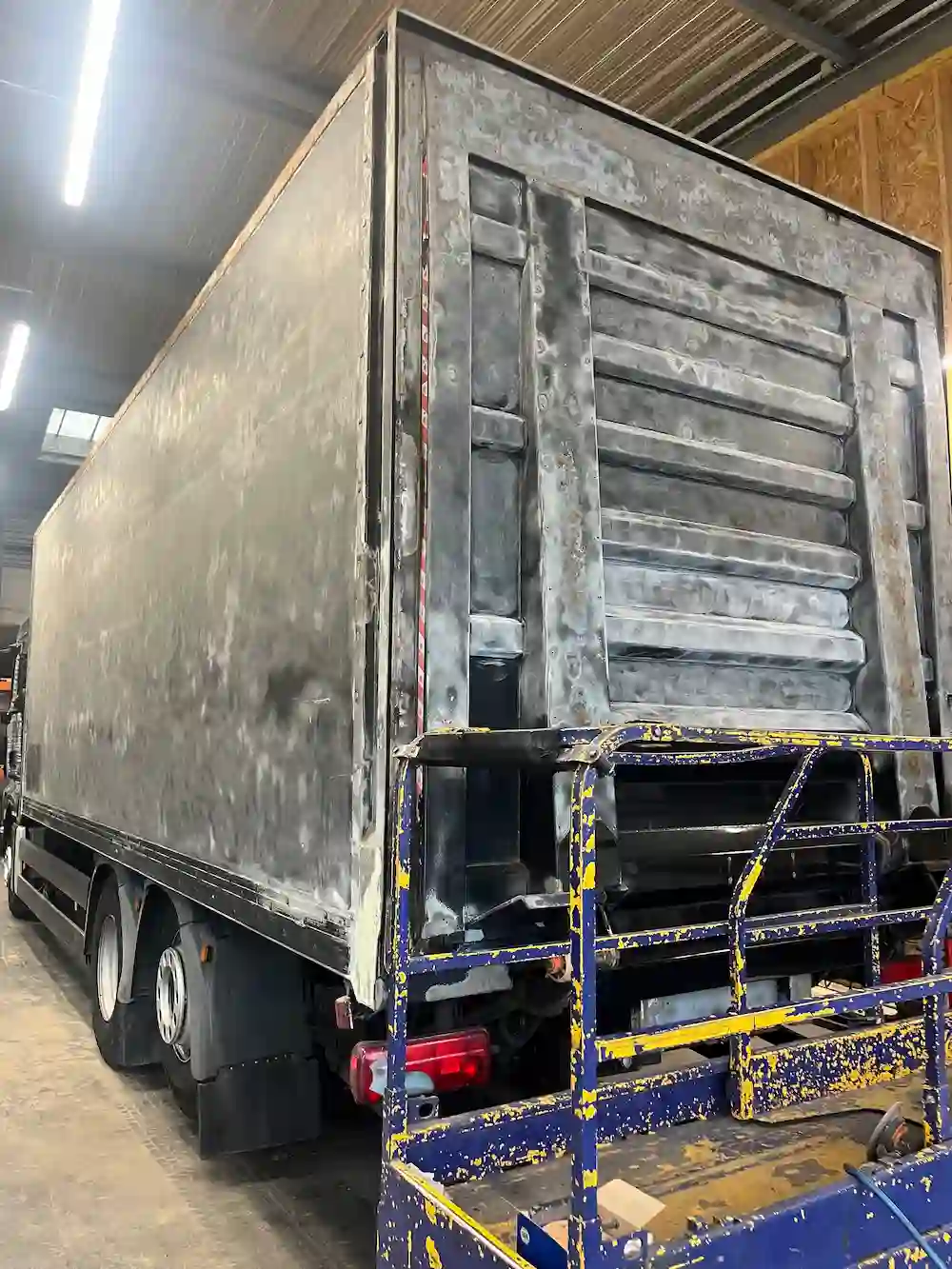 Camion porteur noir MAN TGS en rénovation complète avec sablage et peinture professionnelle haute brillance réalisé par Green Flag Services